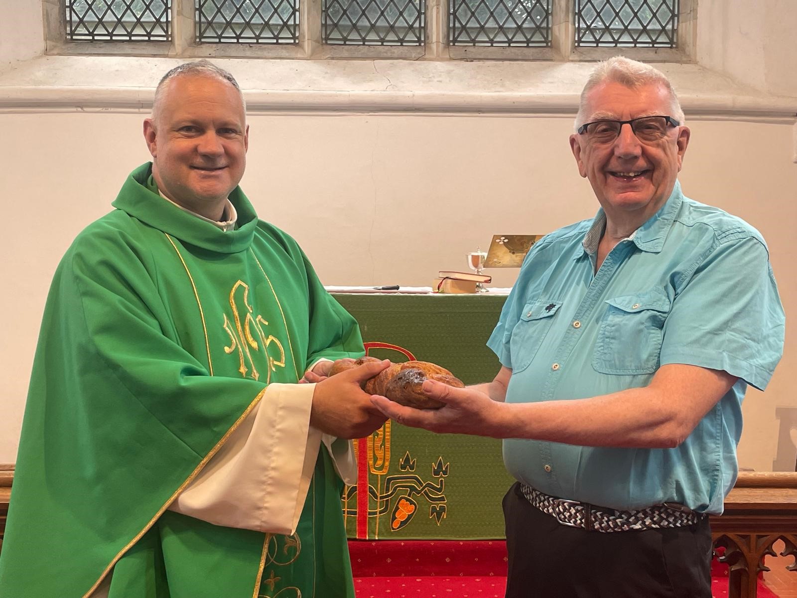 The Revd Andrew Birks (Vicar of All Saints' Melbourn and HolyTrinity Meldreth), receives the Lammas loaf from Bob Tulloch, who rose at 5am to bake the bread.